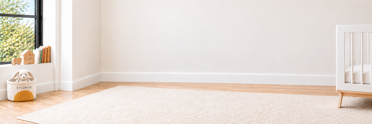 A glimpse of the white and natural wood SYM crib in the bright Sylún room.