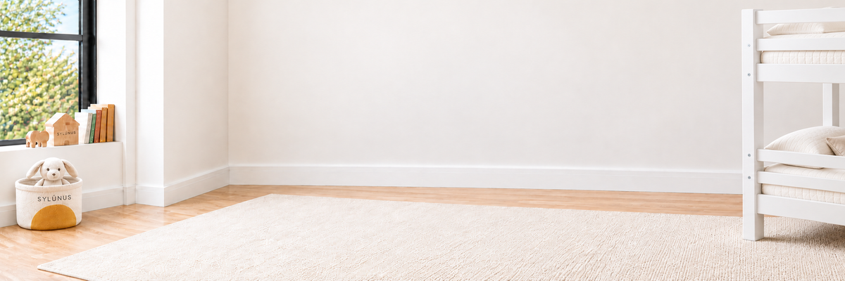 Bright SylúnUS room with ivory rug and branded bunny basket, with a sliver of a white bunk bed at the far right.